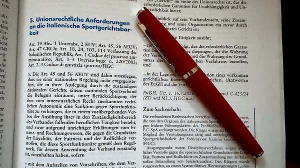 Aufgeschlagene Zeitschrift für Sport und Recht mit rotem Füller, geöffnet bei einem EuGH-Urteil zur italienischen Sportgerichtsbarkeit